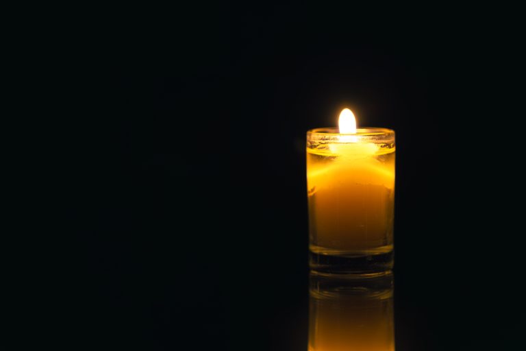 Burning candle on black background with backlight. . Memorial Day. High quality photo